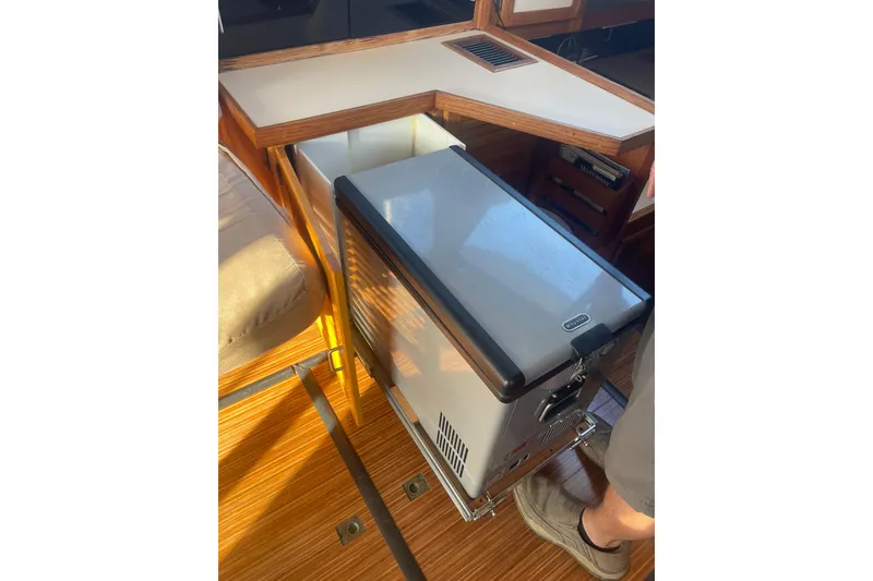 Slide: The Image of 1986 Mainship Mark III Motor Cruiser interior with pull-out fridge and wooden flooring. - 21