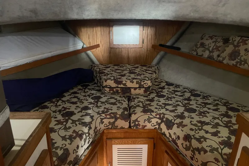 Slide: The Image of 1986 Mainship Mark III Motor Cruiser cabin with floral-patterned bedding and wooden accents. - 24
