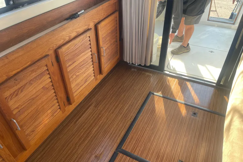 Slide: The Image of 1986 Mainship Mark III Motor Cruiser interior with wooden cabinets and flooring. - 34