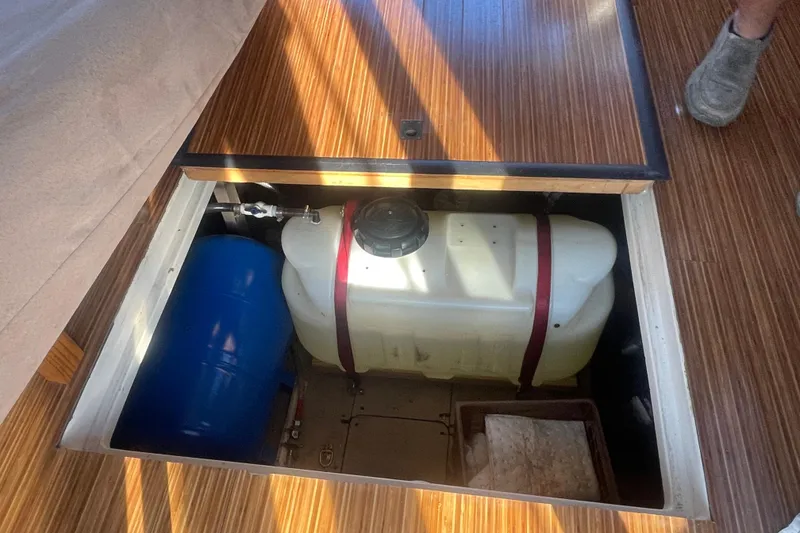 Slide: The Image of 1986 Mainship Mark III Motor Cruiser interior storage compartment with tanks and wooden flooring. - 38