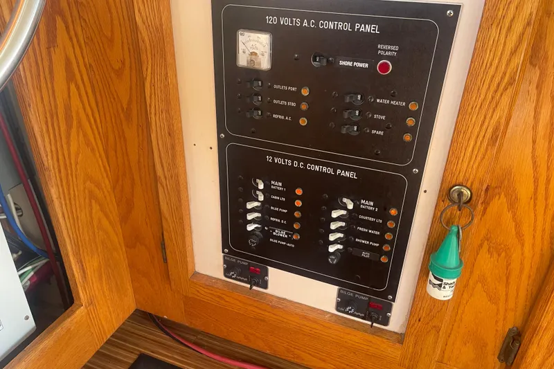 Slide: The Image of Control panel of a 1986 Mainship Mark III Motor Cruiser with AC and DC switches. - 42
