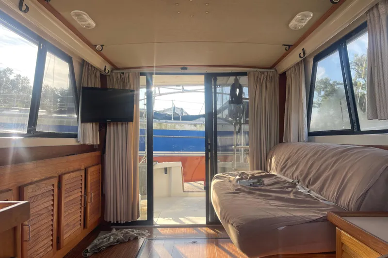 Slide: The Image of Interior of 1986 Mainship Mark III Motor Cruiser with sofa, TV, and sliding glass door. - 48