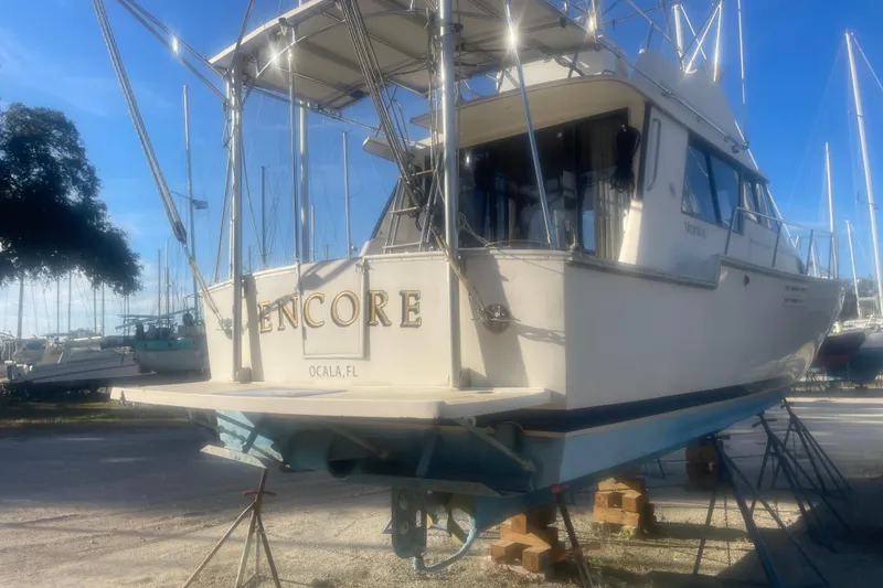 Slide: The Image of 1986 Mainship Mark III Motor Cruiser on stands, labeled "Encore," in a marina setting. - 5