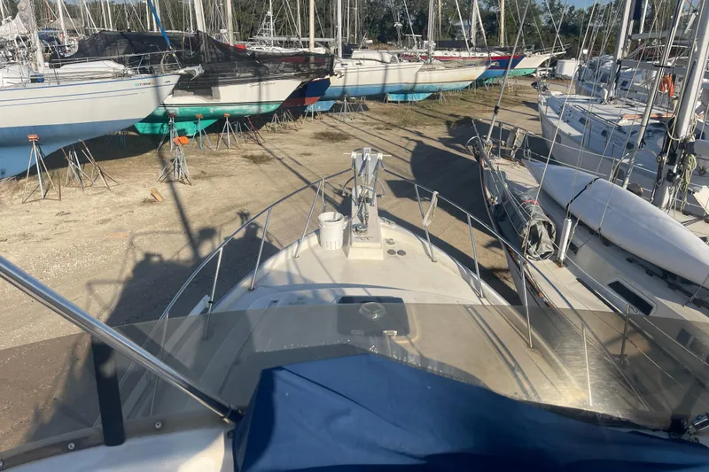 Slide: The Image of 1986 Mainship Mark III Motor Cruiser in a boatyard, surrounded by sailboats. - 54