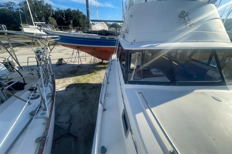 Slide: The Image of 1986 Mainship Mark III Motor Cruiser docked alongside other boats in a marina. - 6