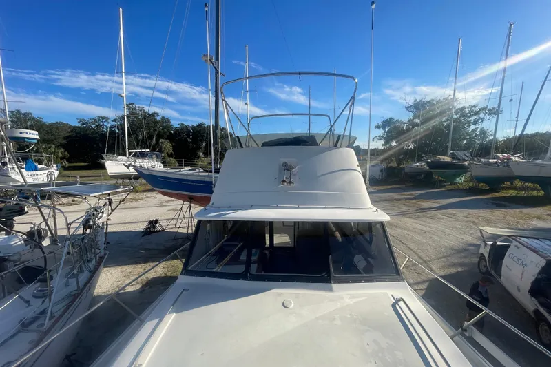 Slide: The Image of 1986 Mainship Mark III Motor Cruiser in a boatyard under clear blue skies. - 9
