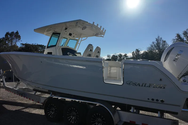 Slide: The Image of 2026 Sailfish 312 CC boat on trailer under bright sun. - 3