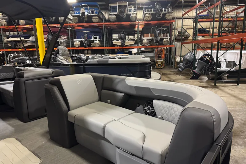 Slide: The Image of 2026 Godfrey Sweetwater 2286 SFL pontoon boat interior in showroom with seating and storage. - 6