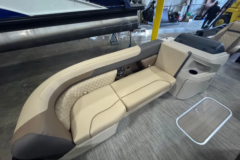 Slide: The Image of 2026 Godfrey Sweetwater 2286 SFL boat interior with beige seating and storage compartment. - 4