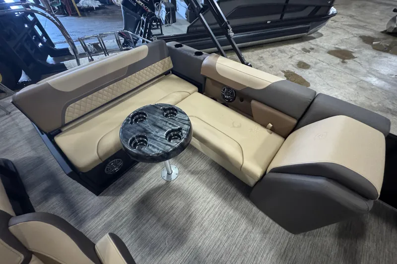 Slide: The Image of 2026 Godfrey Sweetwater 2286 SFL boat interior with beige seating and round table. - 7