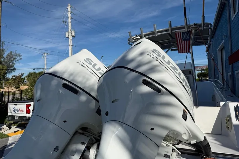 Slide: The Image of Twin Suzuki outboard motors on a 2002 Monza 26 boat, with American flag in background. - 4