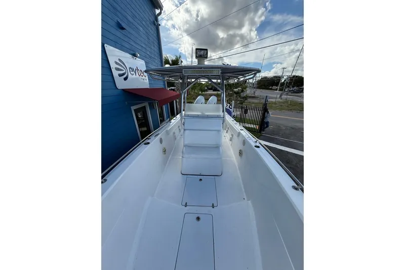 Slide: The Image of 2002 Monza 26 boat with center console, docked near a blue building under cloudy skies. - 9