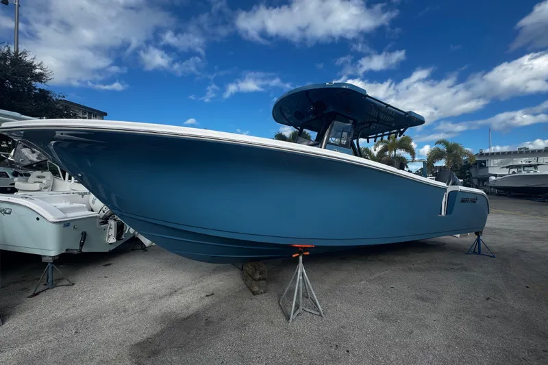 The Image of 2026 Sea Pro 292 DLX boat on stands under a blue sky. - 0
