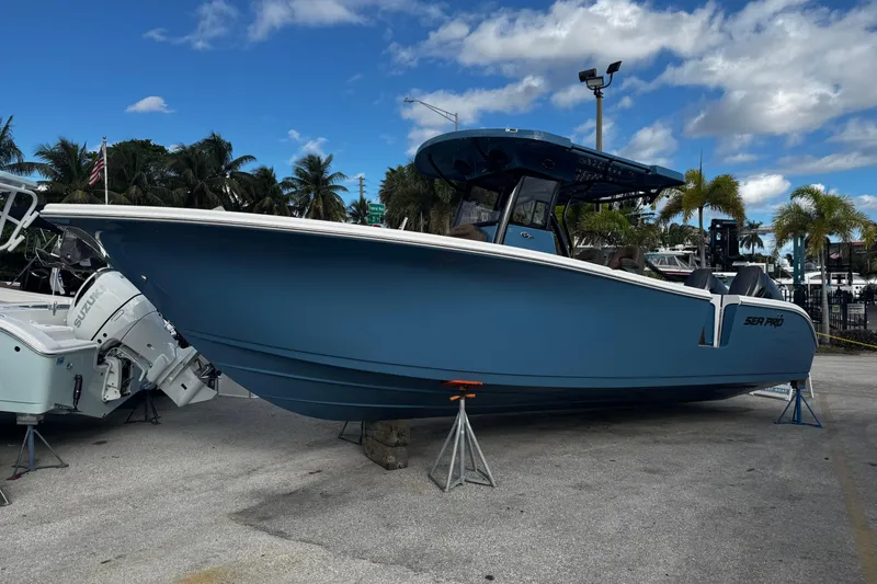 Slide: The Image of 2026 Sea Pro 292 DLX boat displayed outdoors with palm trees and blue sky. - 1