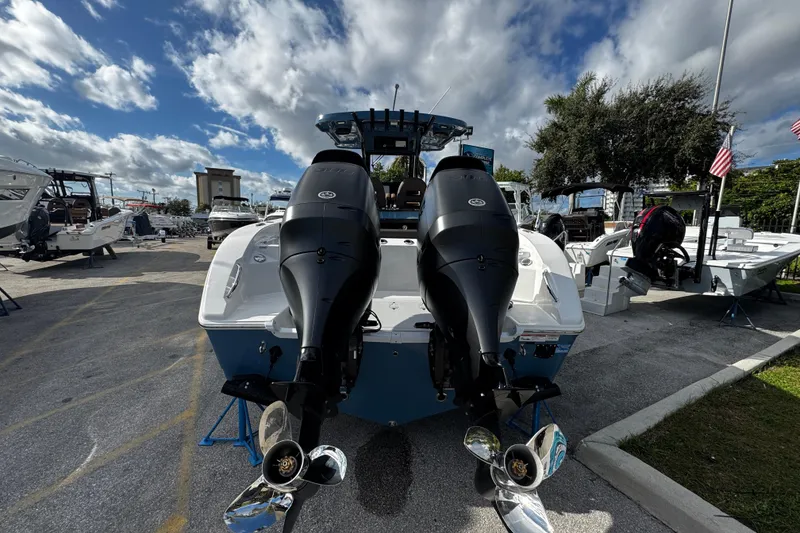 Slide: The Image of 2026 Sea Pro 292 DLX boat with dual outboard motors, displayed outdoors under a cloudy sky. - 10