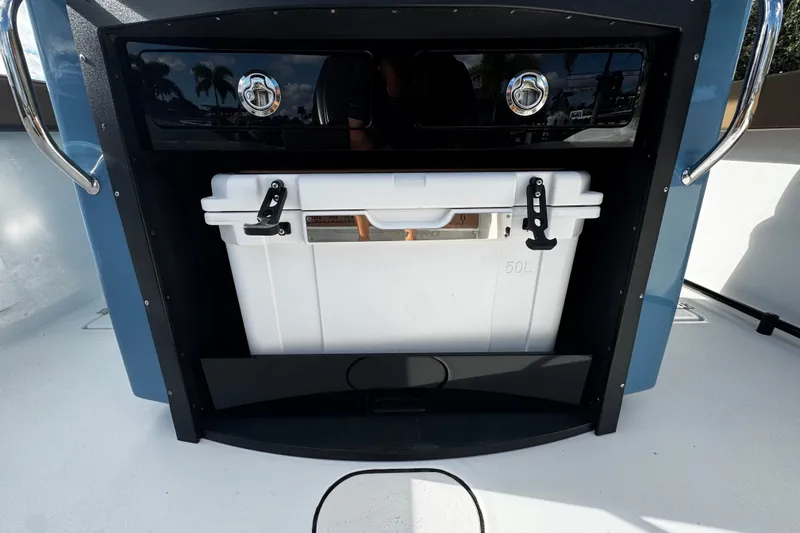 Slide: The Image of 2026 Sea Pro 292 DLX boat storage compartment with a white cooler. - 16