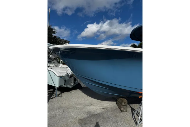Slide: The Image of 2026 Sea Pro 292 DLX boat with sleek blue hull under a clear sky. - 32