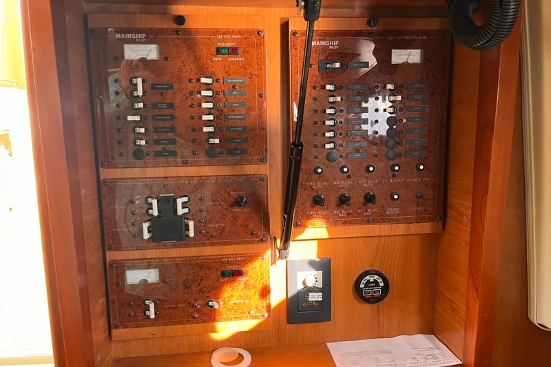 Slide: The Image of Electrical control panel of a 2009 Mainship Pilot 31 boat, featuring switches and gauges. - 16