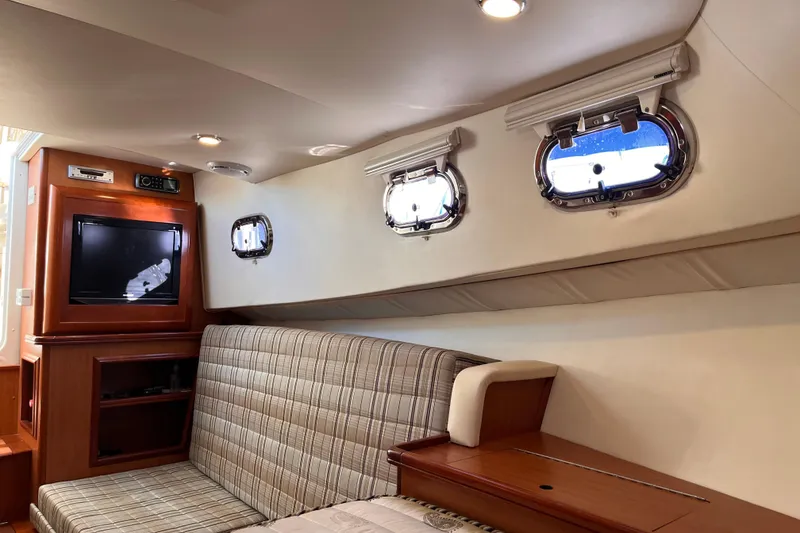 Slide: The Image of Interior of 2009 Mainship Pilot 31 boat with seating, windows, and built-in TV. - 18