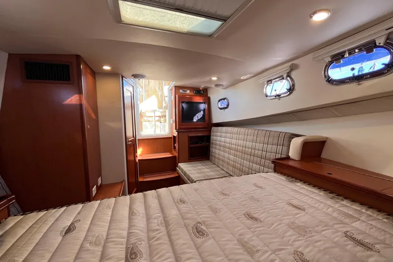 Slide: The Image of 2009 Mainship Pilot 31 cabin interior with bed, seating, and portholes. - 20