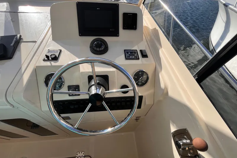 Slide: The Image of 2009 Mainship Pilot 31 helm with steering wheel, gauges, and navigation controls. - 31