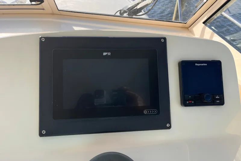 Slide: The Image of 2009 Mainship Pilot 31 dashboard with navigation and control screens. - 33