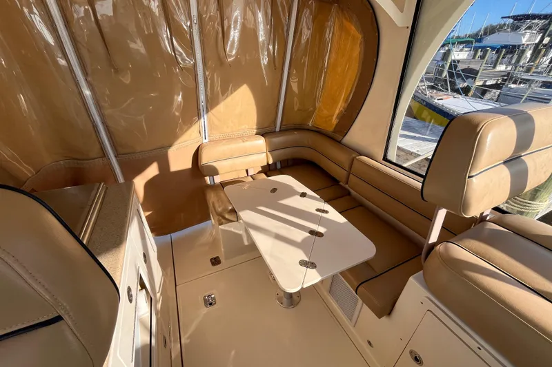 Slide: The Image of 2009 Mainship Pilot 31 interior with beige seating and table, docked at marina. - 38