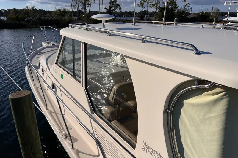 Slide: The Image of 2009 Mainship Pilot 31 boat docked on a sunny day, reflecting water. - 44