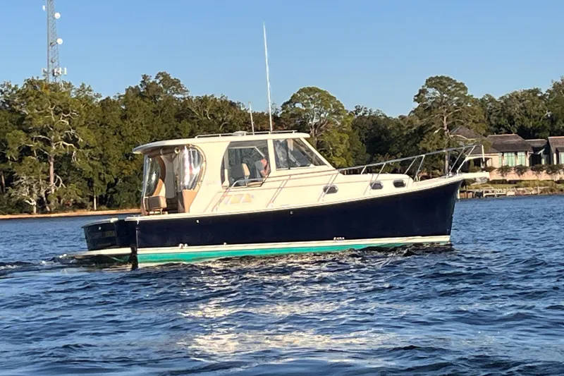 Slide: The Image of 2009 Mainship Pilot 31 cruising on a scenic lake with forested shoreline. - 48