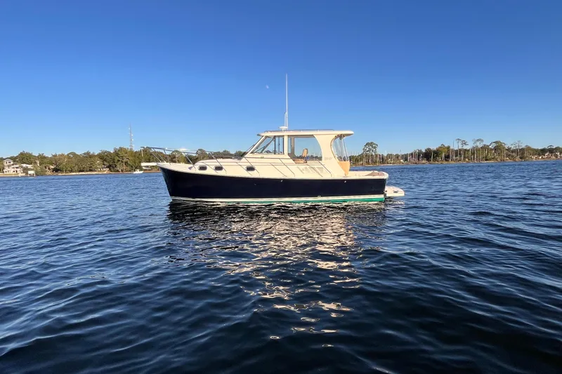 Slide: The Image of 2009 Mainship Pilot 31 boat on calm water under clear blue sky. - 50