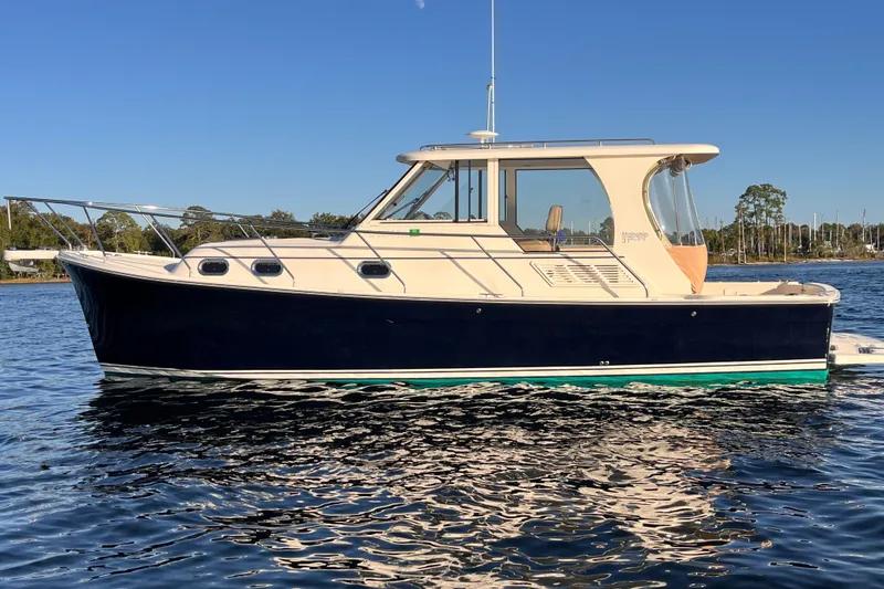 Slide: The Image of 2009 Mainship Pilot 31 boat on calm water under clear blue sky. - 51