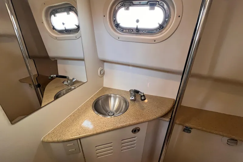 Slide: The Image of 2009 Mainship Pilot 31 bathroom with stainless steel sink and porthole window. - 9