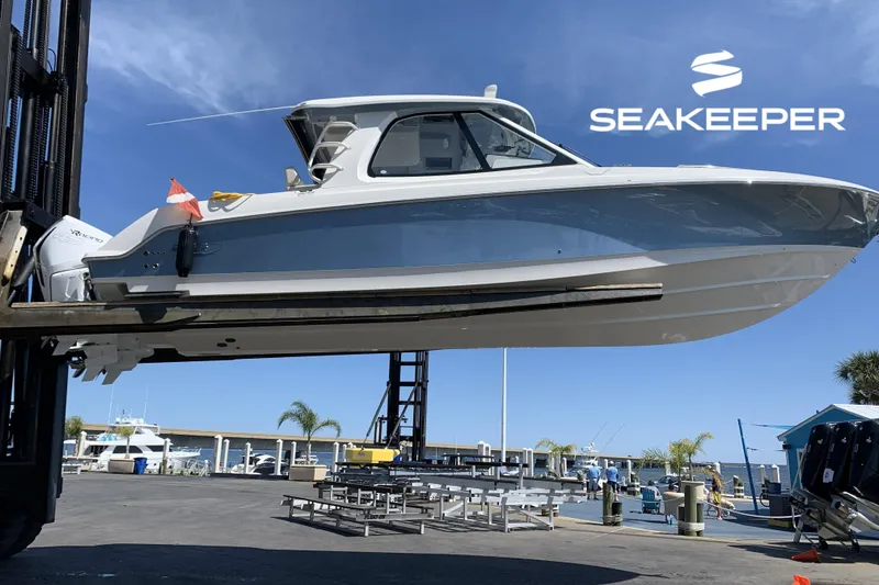 The Image of 2021 Boston Whaler 380 Realm boat lifted at marina with Seakeeper logo. - 0