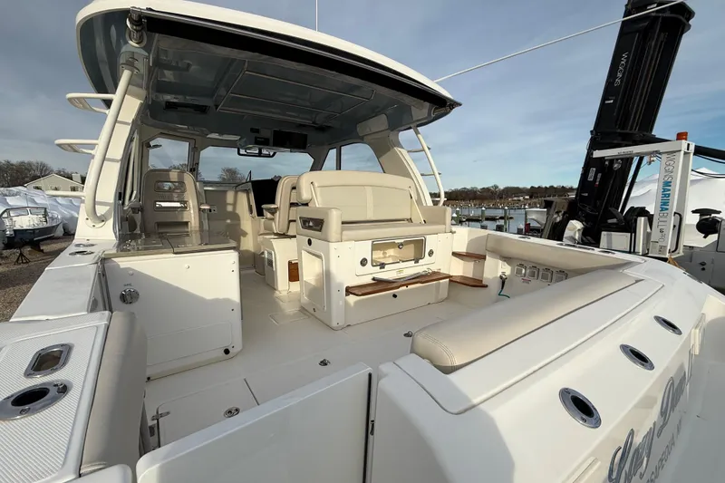 Slide: The Image of 2021 Boston Whaler 380 Realm boat interior with seating and helm, docked at marina. - 11