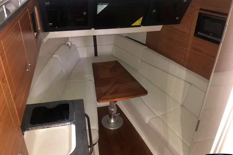 Slide: The Image of Interior of 2021 Boston Whaler 380 Realm with white seating and wooden table. - 19