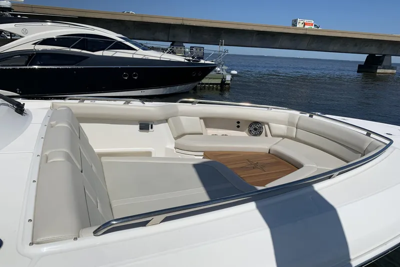 Slide: The Image of 2021 Boston Whaler 380 Realm boat with spacious seating area, docked near a bridge. - 26