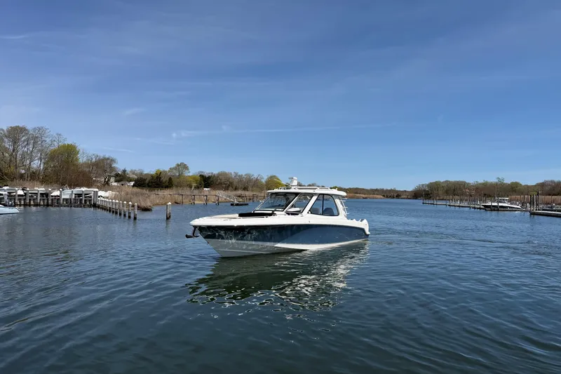 Slide: The Image of 2021 Boston Whaler 380 Realm cruising on a calm river under a clear blue sky. - 30