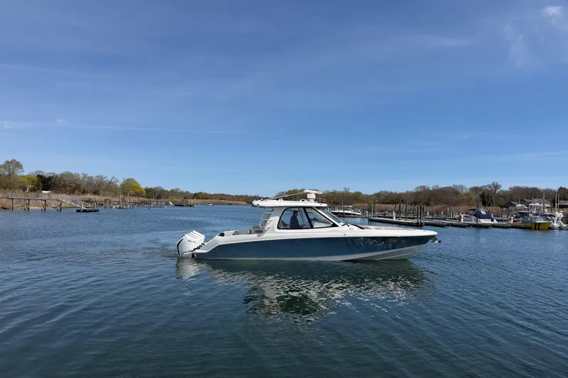 Slide: The Image of 2021 Boston Whaler 380 Realm boat on calm water under clear blue sky. - 33