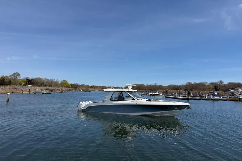 Slide: The Image of 2021 Boston Whaler 380 Realm boat on calm water under clear blue sky. - 34