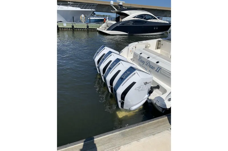 Slide: The Image of 2021 Boston Whaler 380 Realm with quad outboard engines docked at marina. - 5