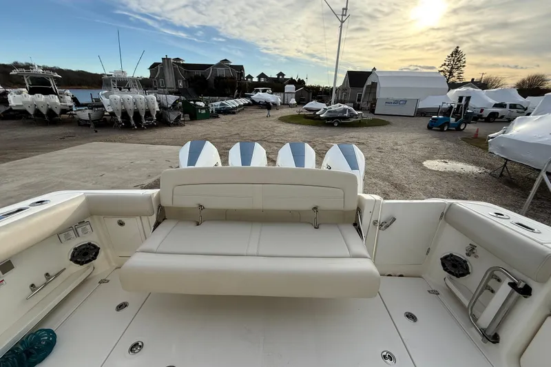 Slide: The Image of 2021 Boston Whaler 380 Realm boat with seating and outboard motors, docked at a marina. - 9