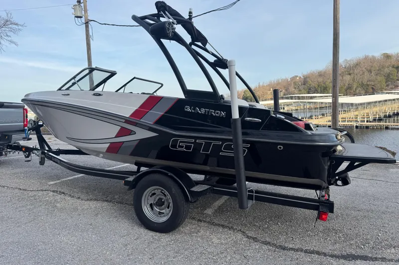 Slide: The Image of 2015 Glastron GTS 187 boat on trailer near waterfront, showcasing sleek design and vibrant colors. - 11