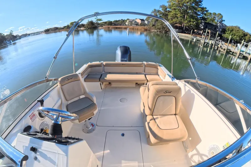 Slide: The Image of 2017 Scout 210 Dorado boat interior with seating, steering wheel, and scenic water view. - 12