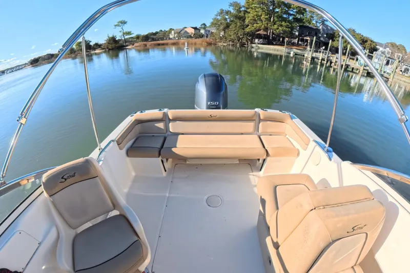 Slide: The Image of 2017 Scout 210 Dorado boat interior with seating, on calm water near a dock. - 16