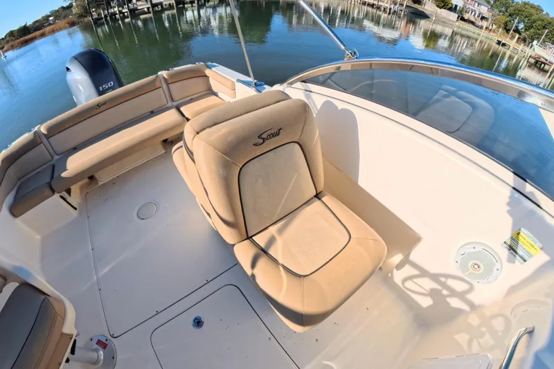 Slide: The Image of 2017 Scout 210 Dorado boat interior with cushioned seating and water view. - 18