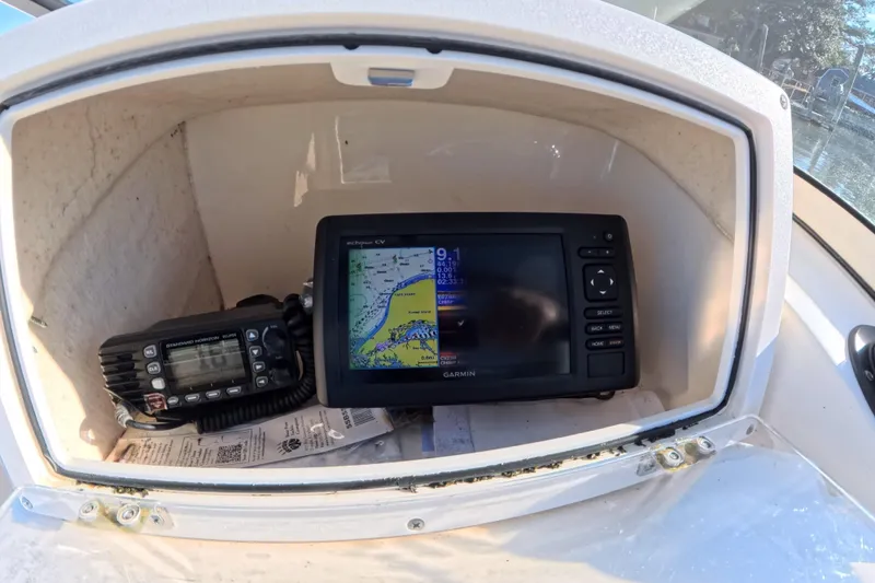 Slide: The Image of Garmin GPS and radio equipment inside 2017 Scout 210 Dorado boat compartment. - 26