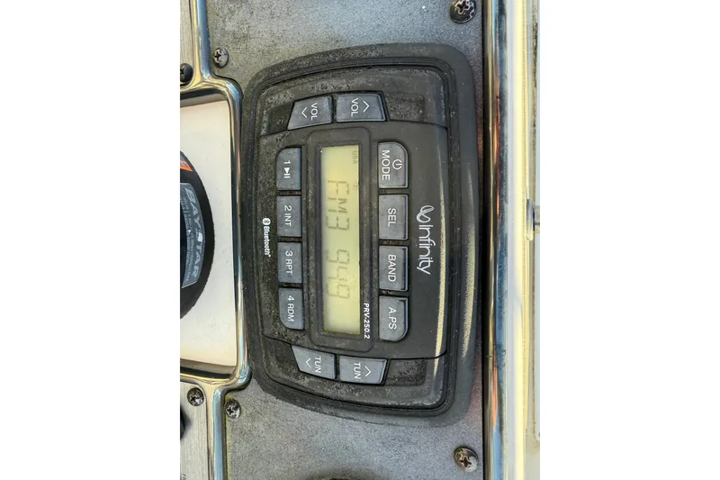 Slide: The Image of Infinity stereo system on 2017 Scout 210 Dorado boat dashboard, displaying FM 94.9. - 29