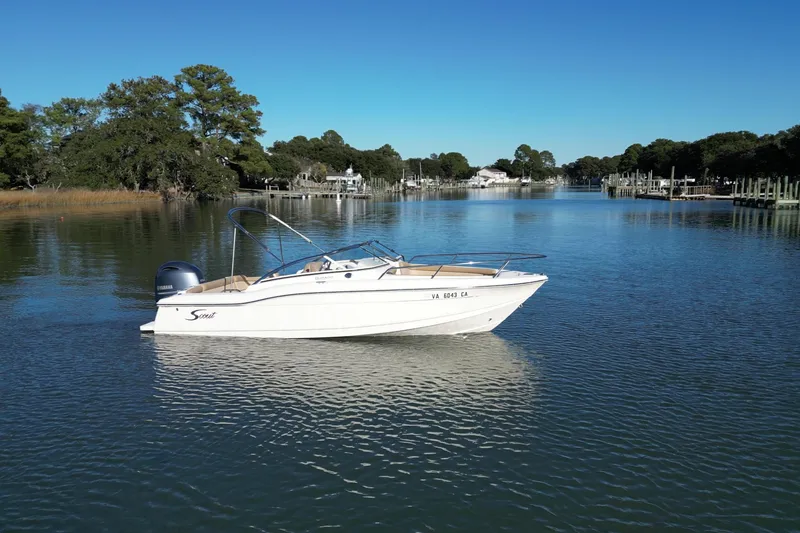 Slide: The Image of 2016 Scout 210 Dorado boat on a serene river with lush greenery. - 3