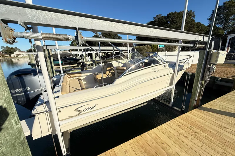 Slide: The Image of 2017 Scout 210 Dorado boat on lift, featuring Yamaha engine, dockside view. - 6