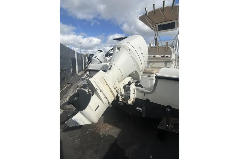 Slide: The Image of 2005 Hydra-Sports 212 CC boat with outboard motor, parked outdoors under cloudy sky. - 11